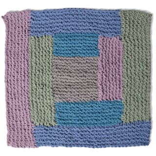 Knitted Square in the Log Cabin Design with shades of blue, green, and purple yarn colors.