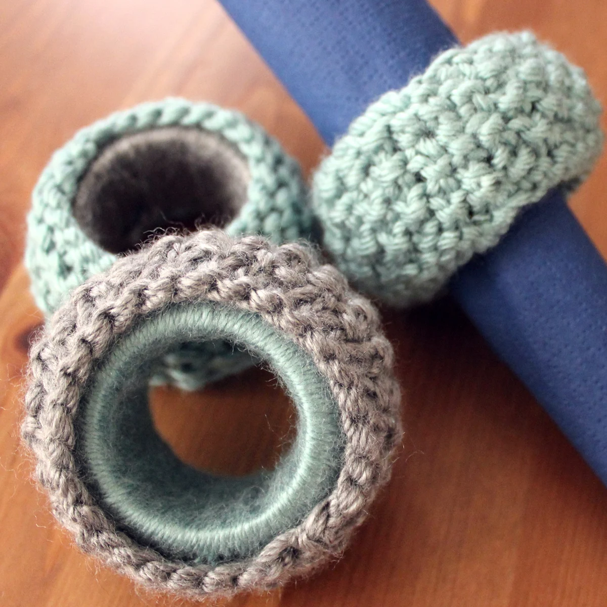 Knitted napkin rings in blue and grey yarn colors.