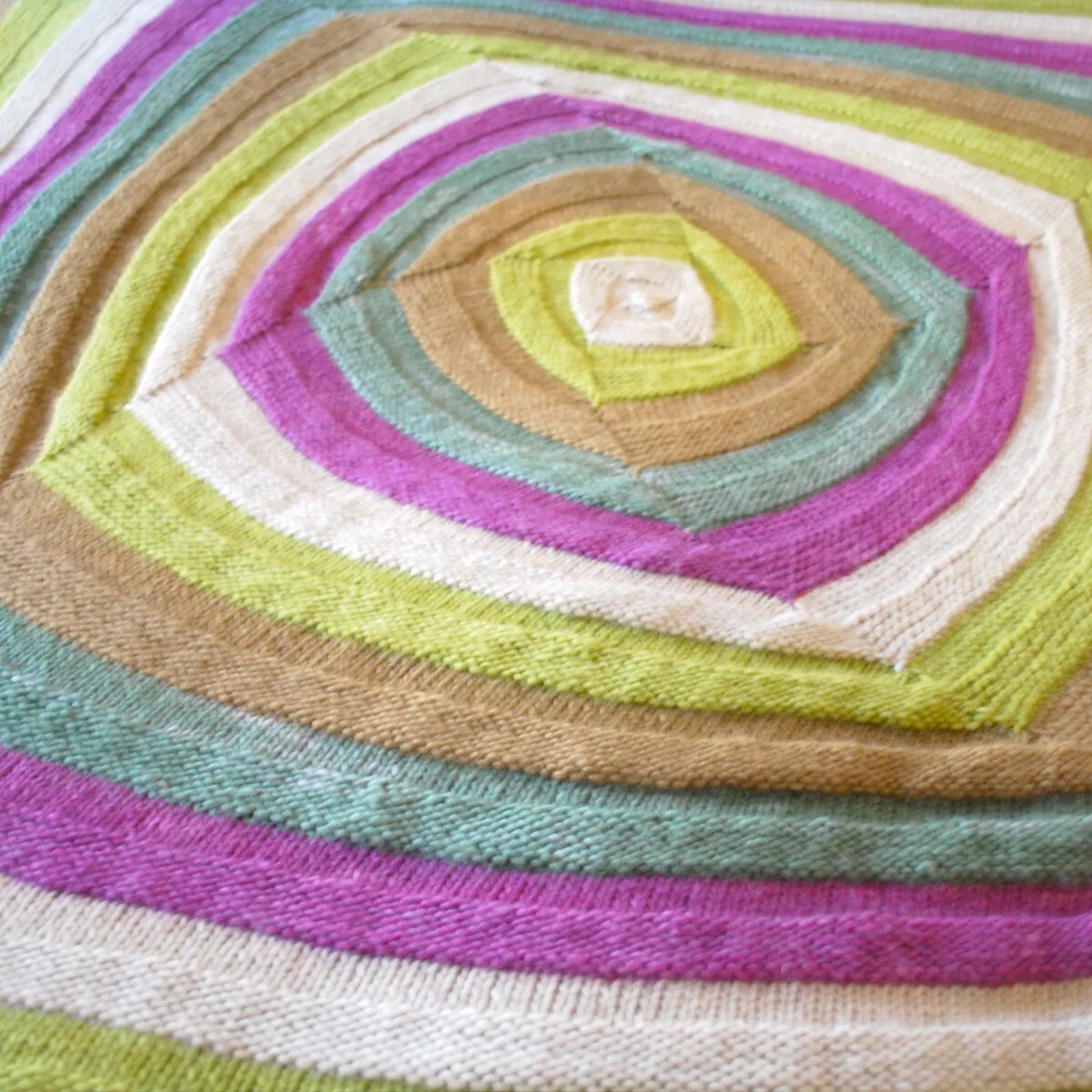 Swirly Square Knit Stitch Pattern texture in multiple yarn colors.