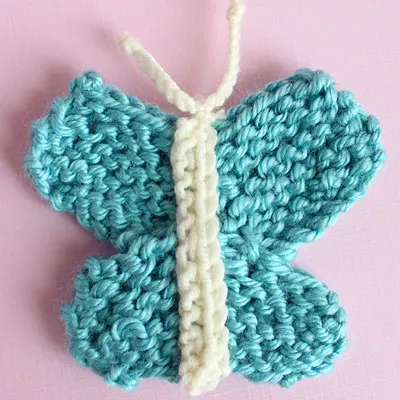 Knitted butterfly shape in blue yarn.