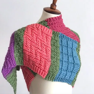Colorful knitted scarf in different knit stitch textures on mannequin.