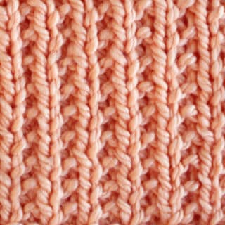 Broken Rib Stitch Knitting Pattern swatch in peach color yarn.