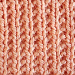 Broken Rib Stitch Knitting Pattern swatch in peach color yarn.