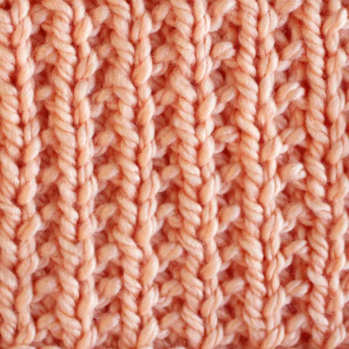 Broken Rib Stitch Knitting Pattern swatch in peach color yarn.