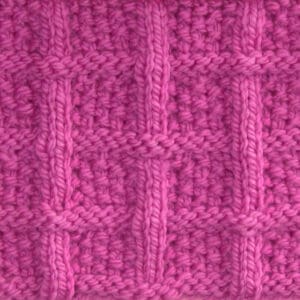 Lattice Seed Knit Stitch Pattern texture in pink color yarn on knitting needle atop a pink background.