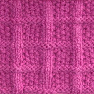 Lattice Seed Knit Stitch Pattern texture in pink color yarn on knitting needle atop a pink background.