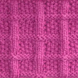 Lattice Seed Knit Stitch Pattern texture in pink color yarn on knitting needle atop a pink background.