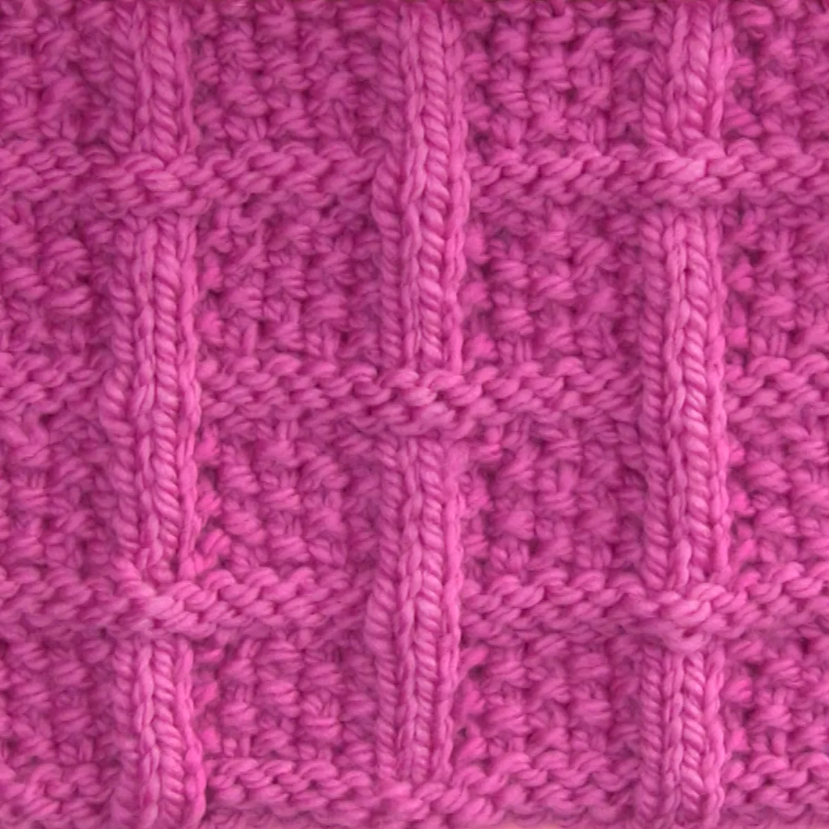 Lattice Seed Knit Stitch Pattern texture in pink color yarn on knitting needle atop a pink background.