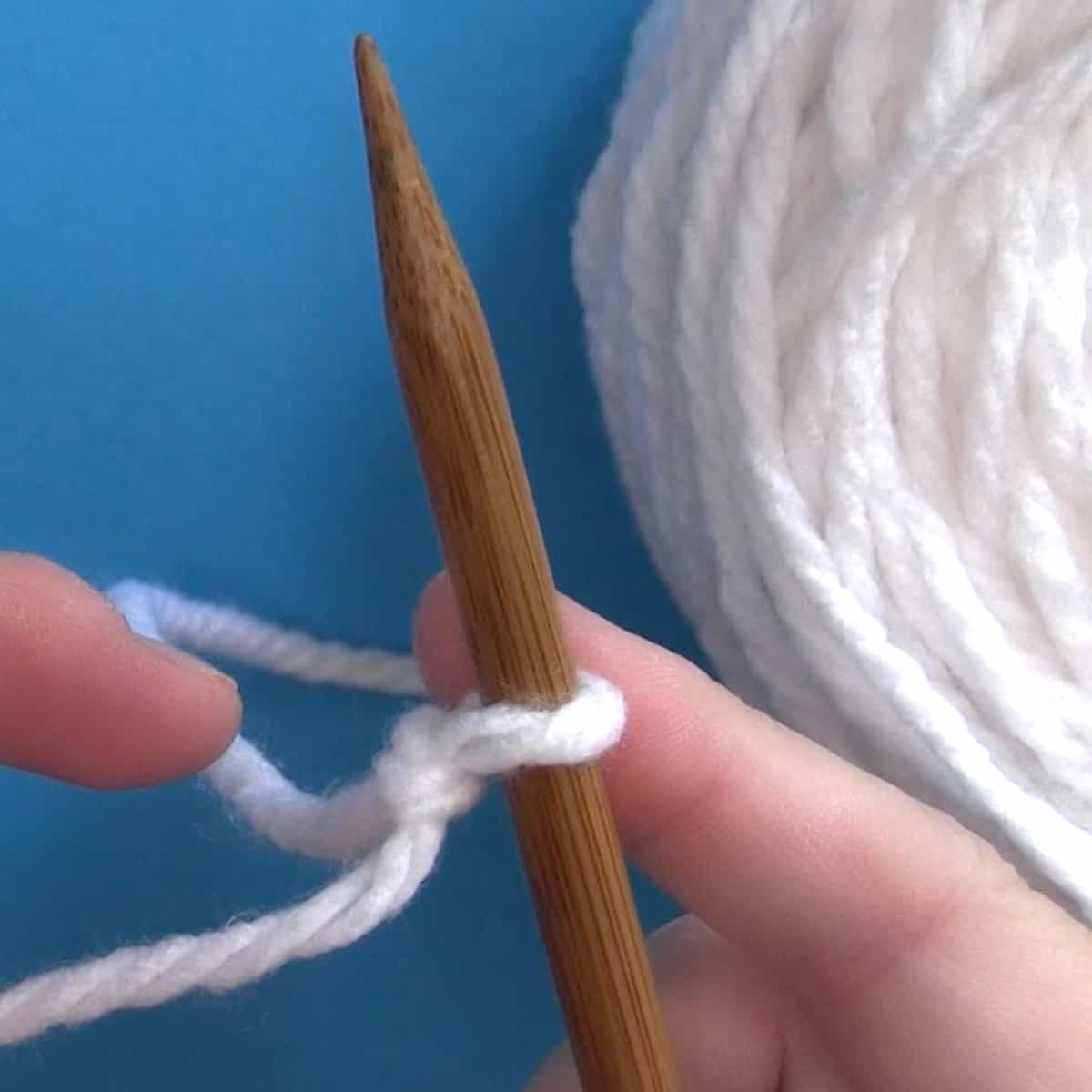 Slip Knot on knitting needle with white yarn.