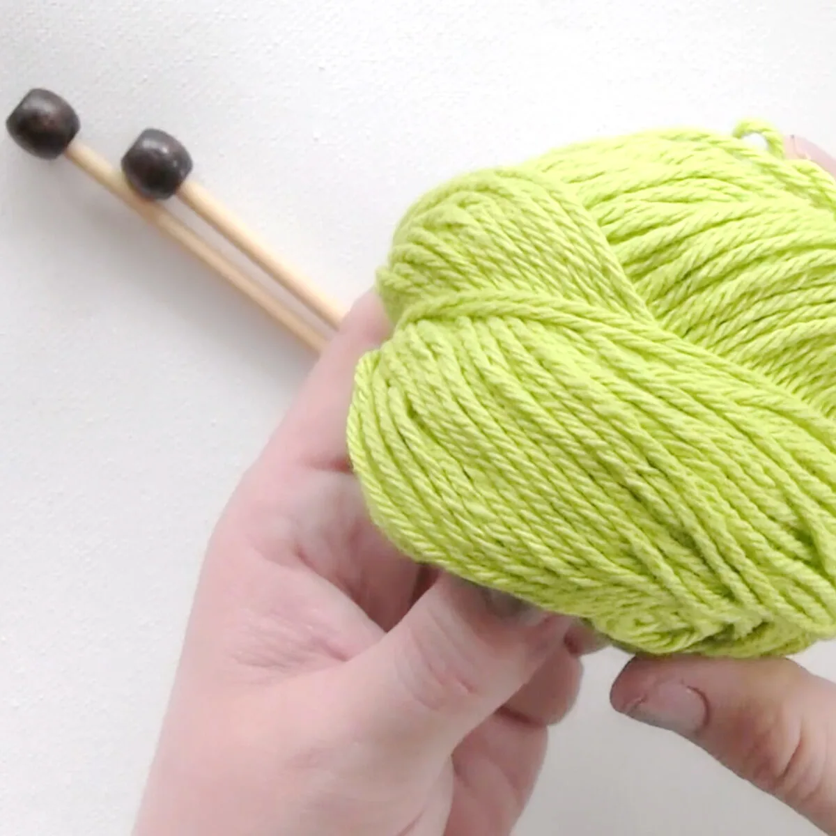Green cotton yarn and knitting needles.