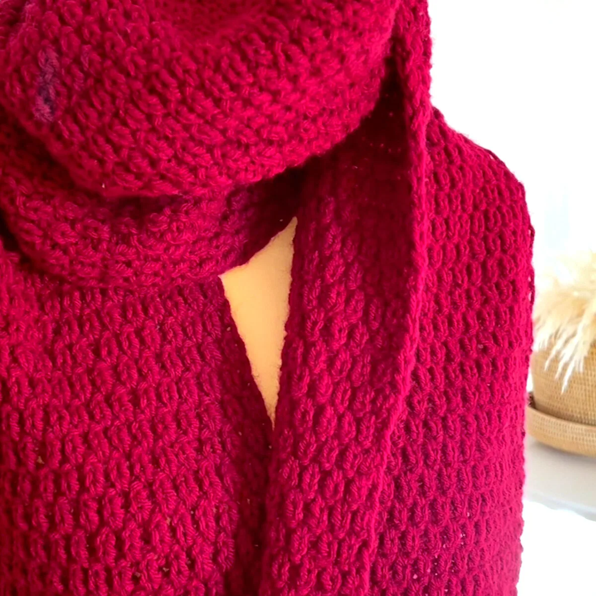 Reversible sides of a red knitted scarf.