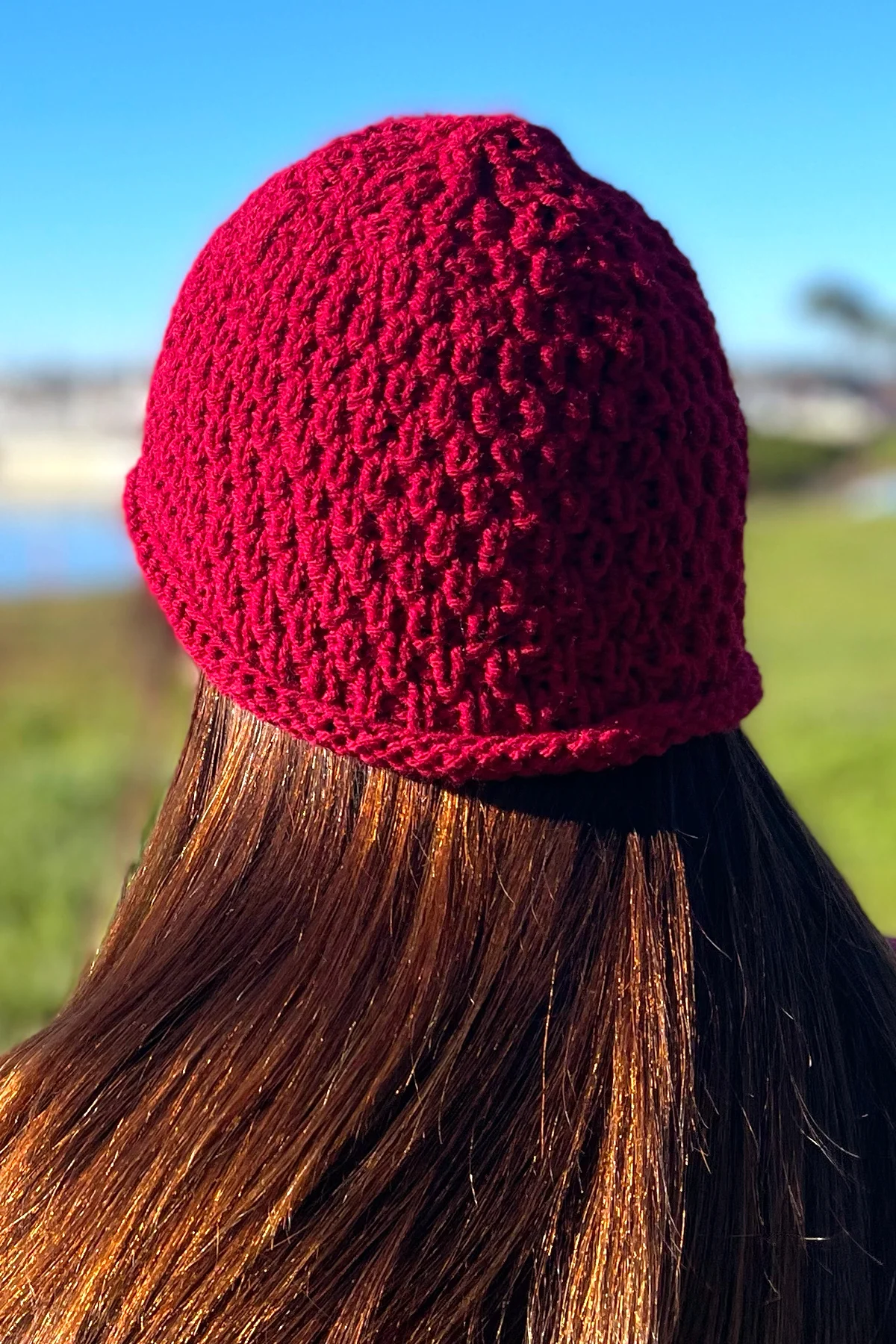 Knitted hat in red yarn in textured Swift Stitch by Studio Knit.