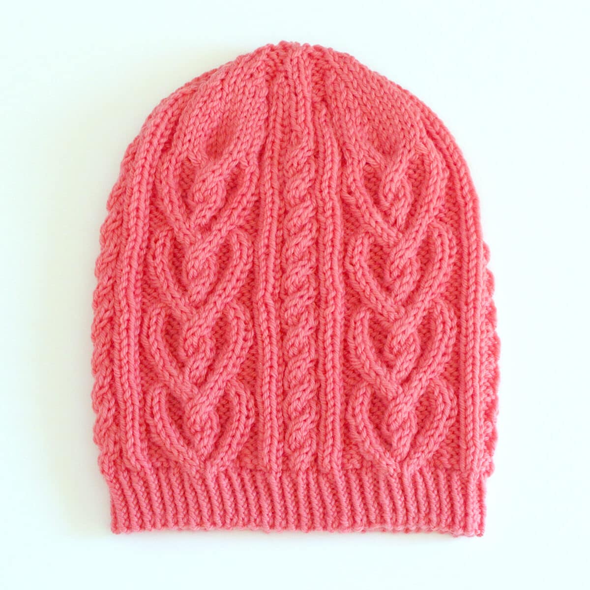 Finished knitted Heart Cable Hat in orange yarn color.