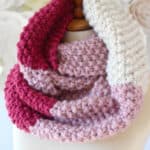Seed Stitch Infinity Scarf in pink and red yarn colors with knitting pattern.