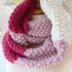 Seed Stitch Infinity Scarf in pink and red yarn colors with knitting pattern.
