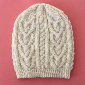 Cable Heart Hat Knitted in cream color yarn by Studio Knit.