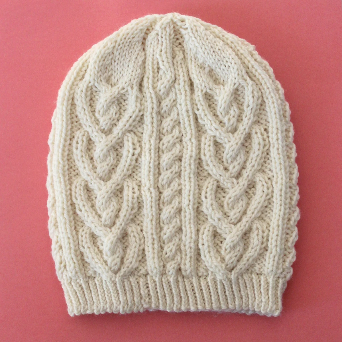 Cable Heart Hat Knitted in cream color yarn by Studio Knit.