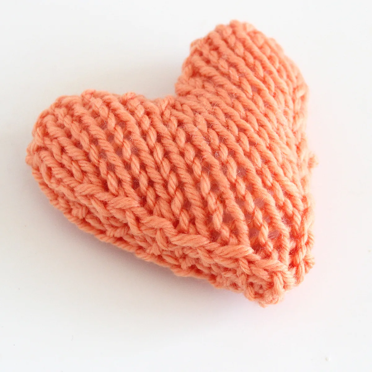 Heart Softie knitted in orange yarn.