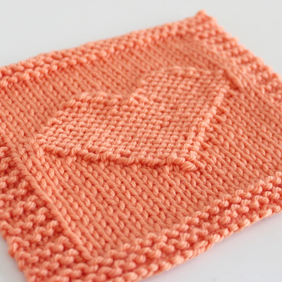 Heart Square knitted in orange color yarn.