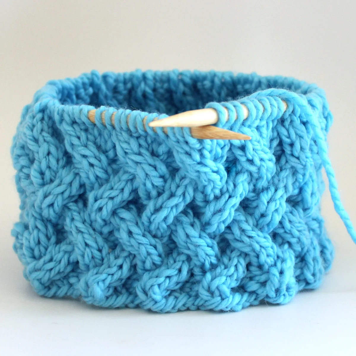 Lattice Cable Stitch on circular needles knitted in the round with blue color yarn.