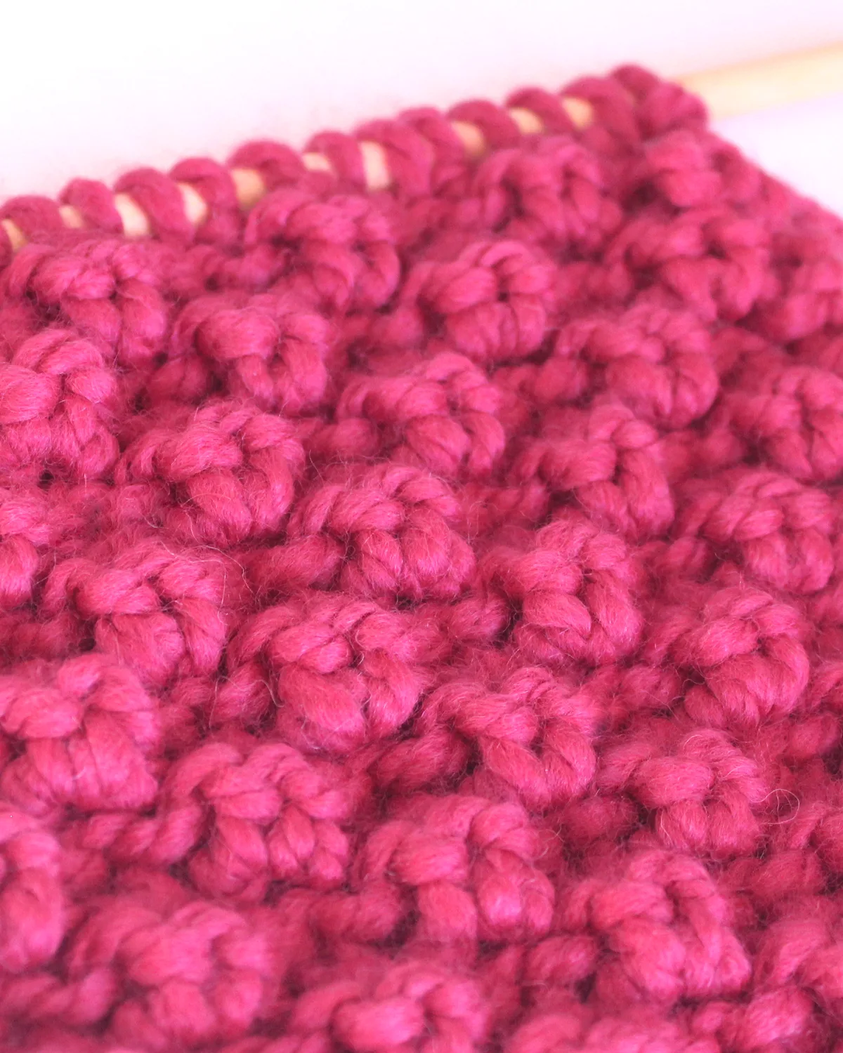Close up of Raspberry Stitch pattern on knitting needle.