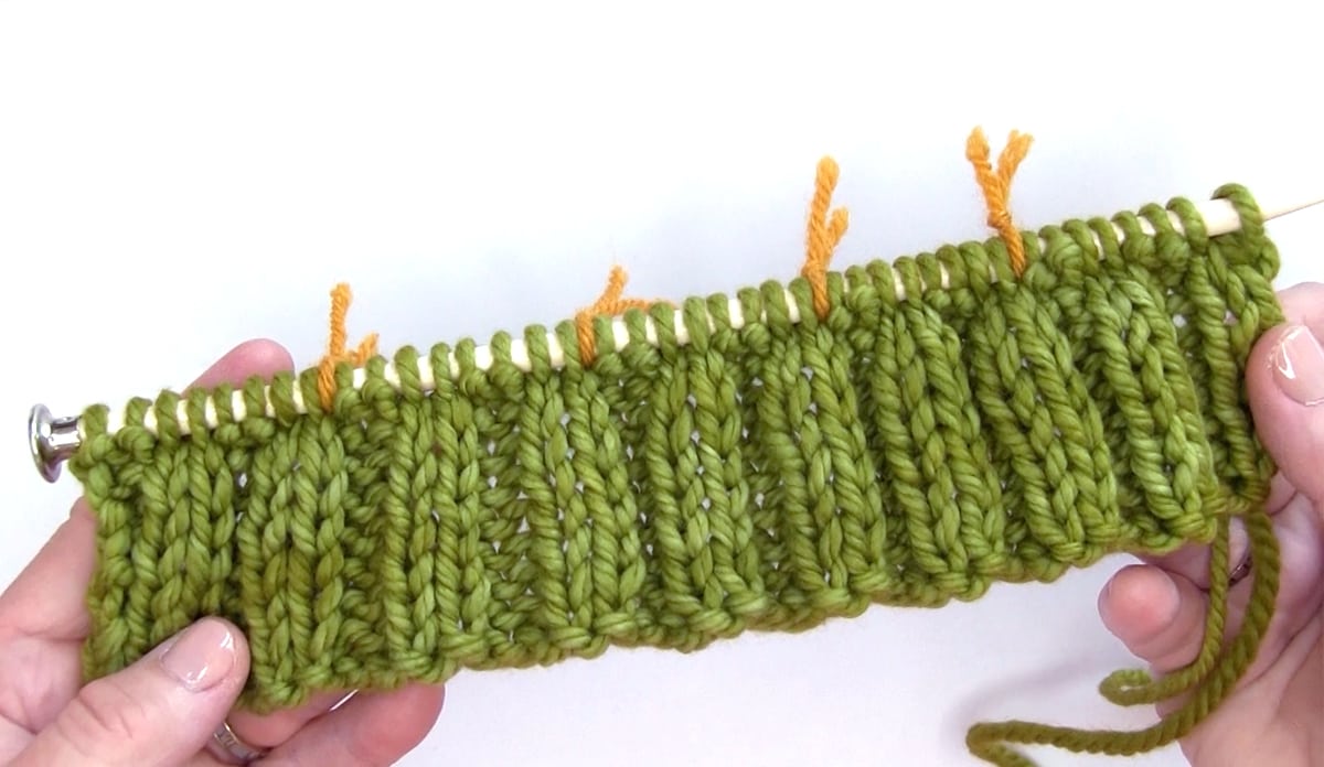 2x2 Rib stitch knitting on needle with green color yarn.