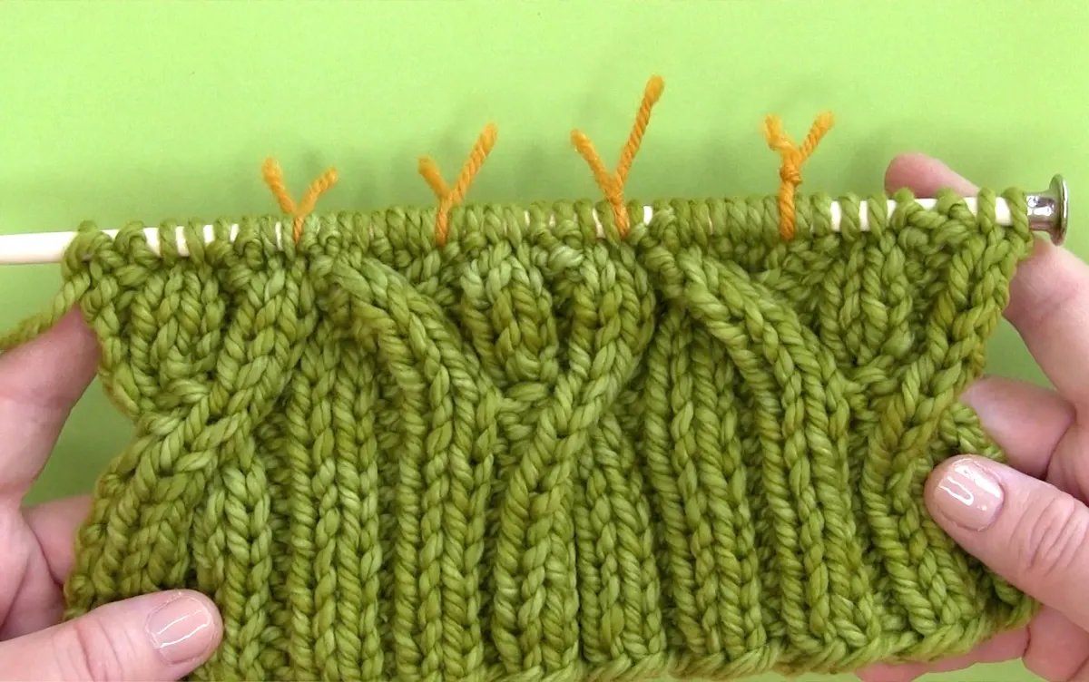 Vine Cable Stitch Pattern rows 1 through 8 on knitting needle.