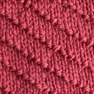 Diagonal Seed Knit Stitch Pattern in pink yarn.
