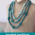 Knitted Necklace with Beaded Texture in blue and white yarn colors displayed on a mannequin.