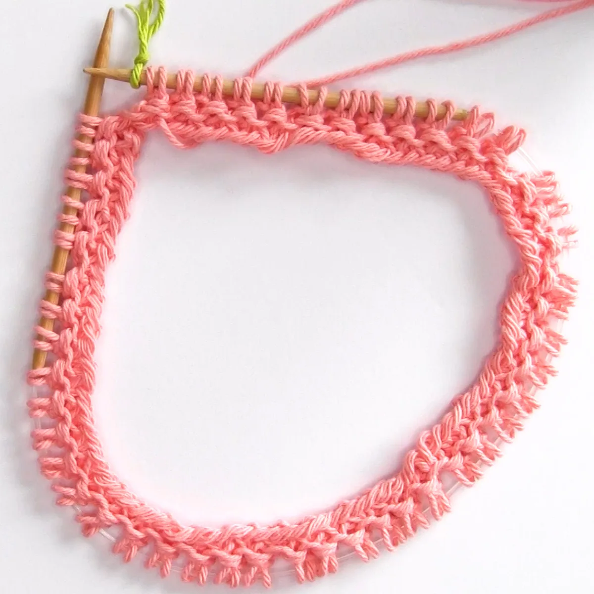 Granite stitch on circular knitting needle in orange color yarn.