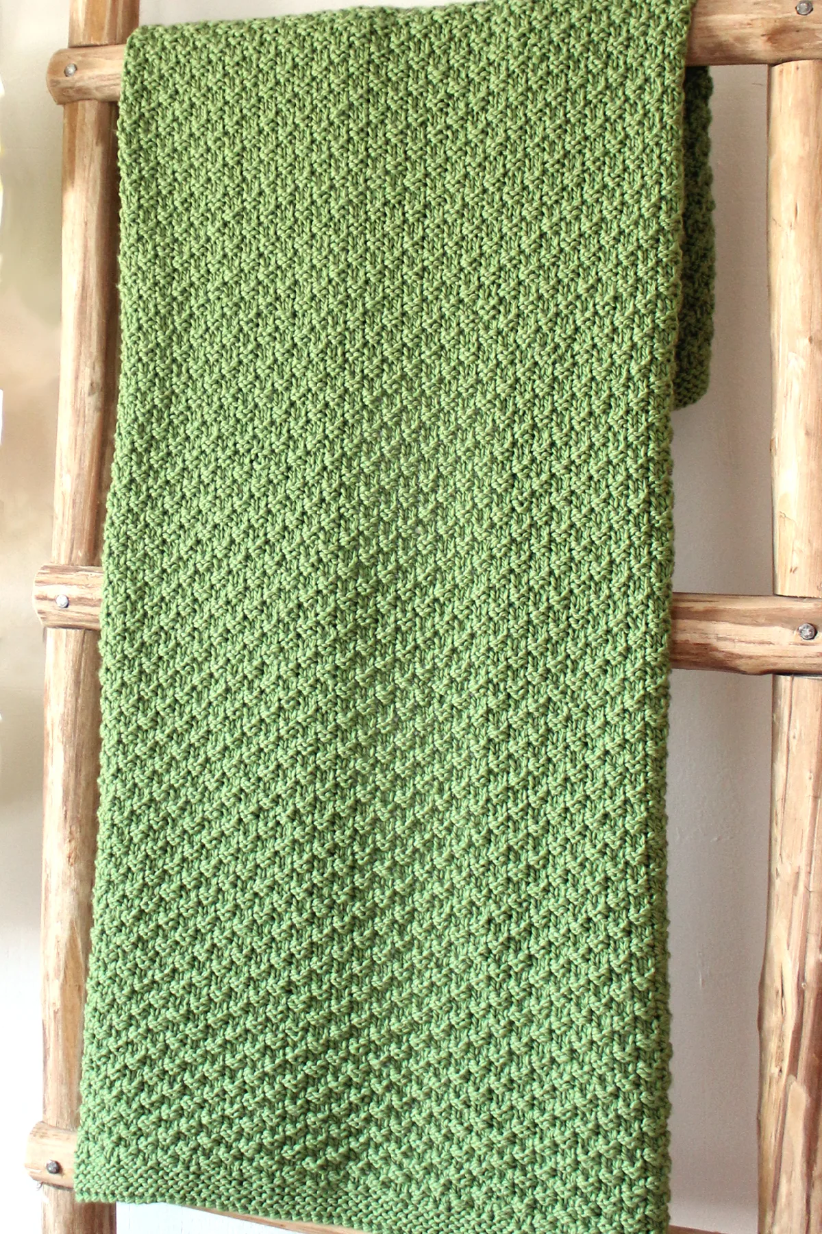 Lapghan sized knitted blanket in green yarn color with Double Moss Stitch.