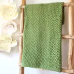 Wooden ladder with Moss Landing knitted blanket by Studio Knit in green yarn color.