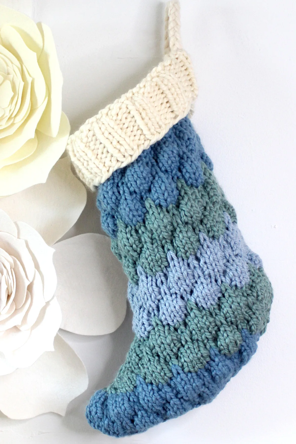 Knitted Bubble Stocking with three shades of blue yarn and a cream color cuff.