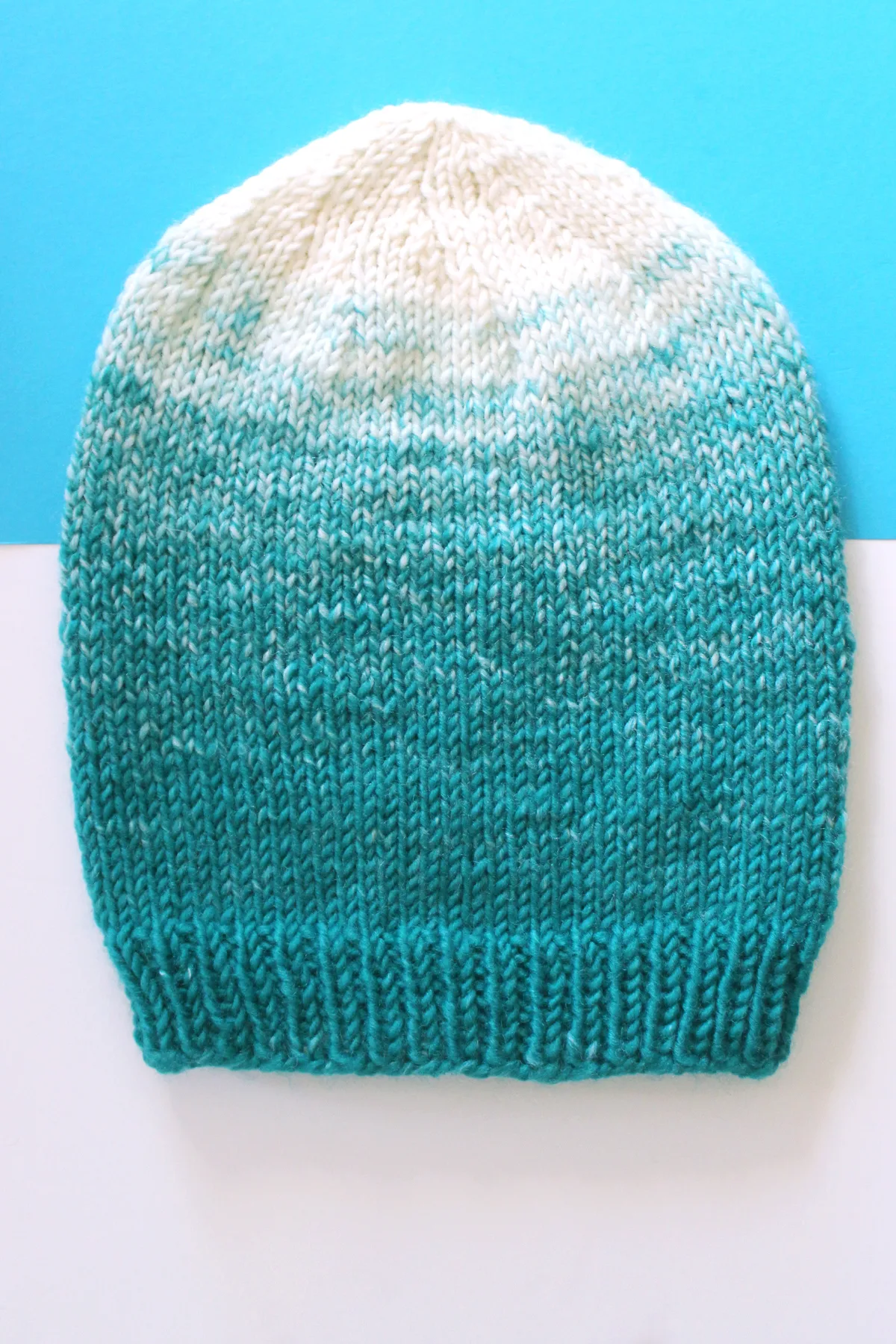 Slouchy Beanie knitted in blue to white ombre yarn colors.