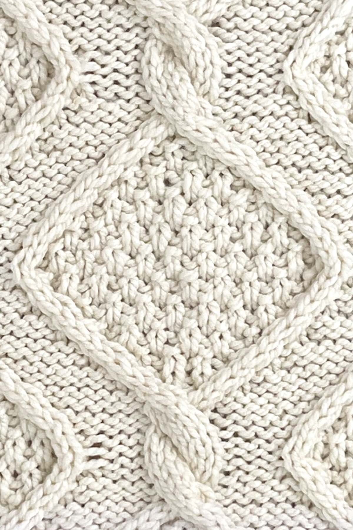 Diamond cable with double moss stitch pattern inside with rope twists atop a reverse stockinette background.