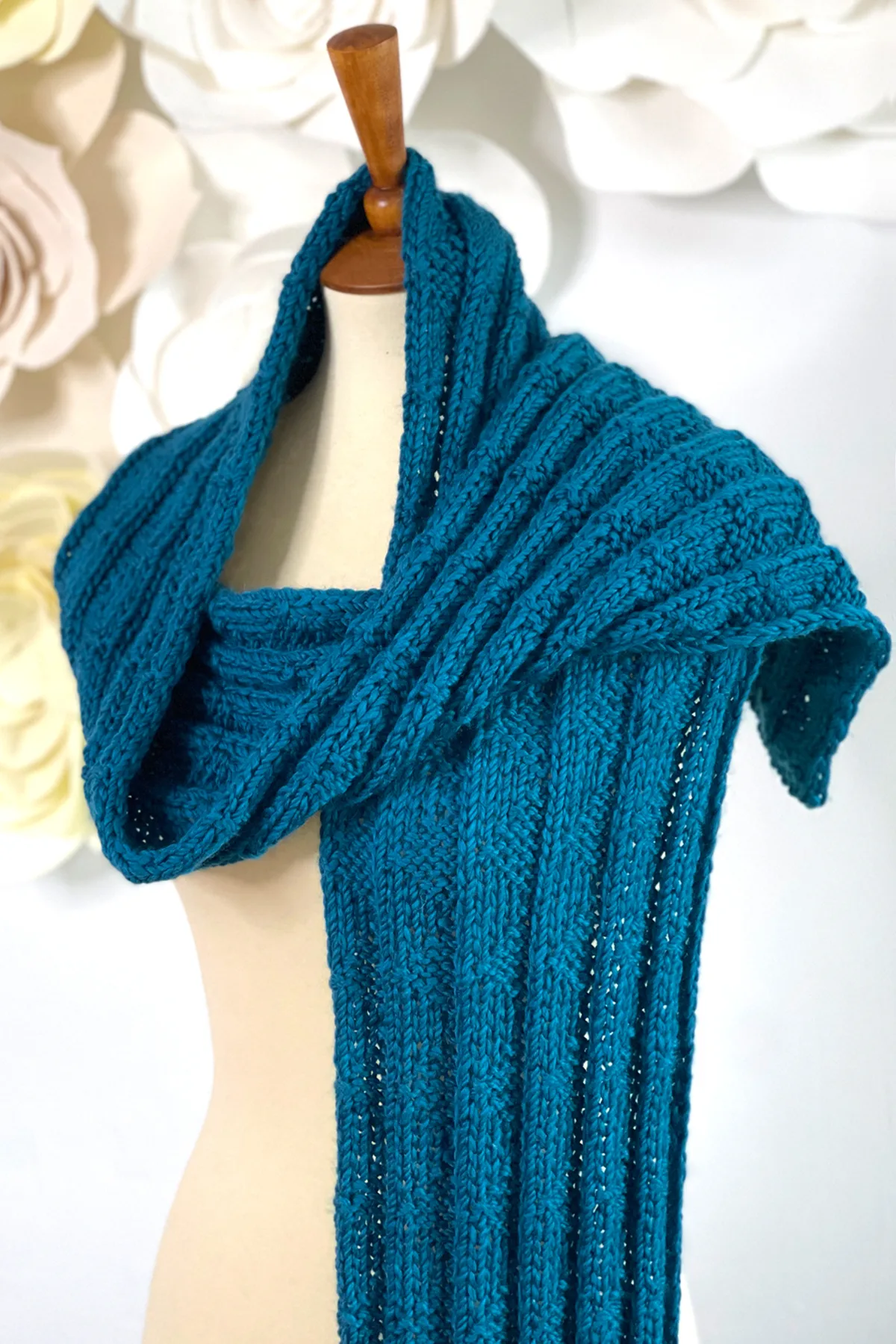 Knitted Pennant Pleating designed by Studio Knit scarf wrapped on mannequin in blue color yarn.