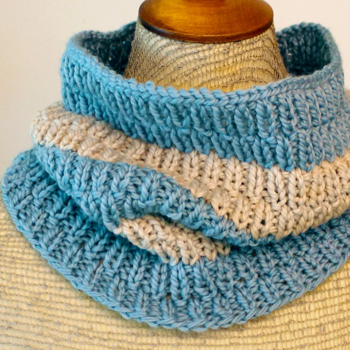 Short Cowl Scarf with long raindrops texture knit in in two colors of beige and light blue yarn color displayed on mannequin.
