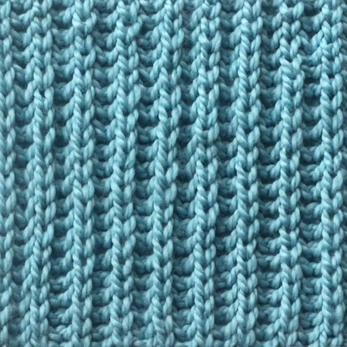 Fisherman's Rib knit stitch pattern knitted flat in light blue yarn color.