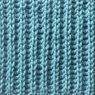 Fisherman's Rib knit stitch pattern knitted flat in light blue yarn color.