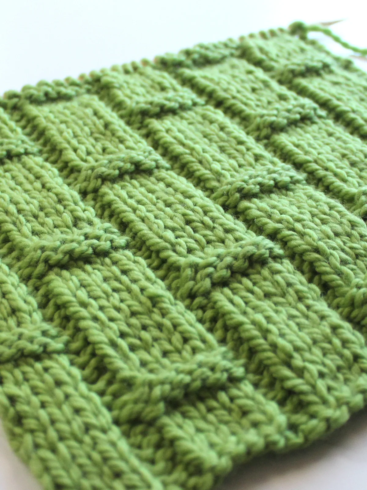 Close-up of bamboo ribbing knitted texture in green yarn color.