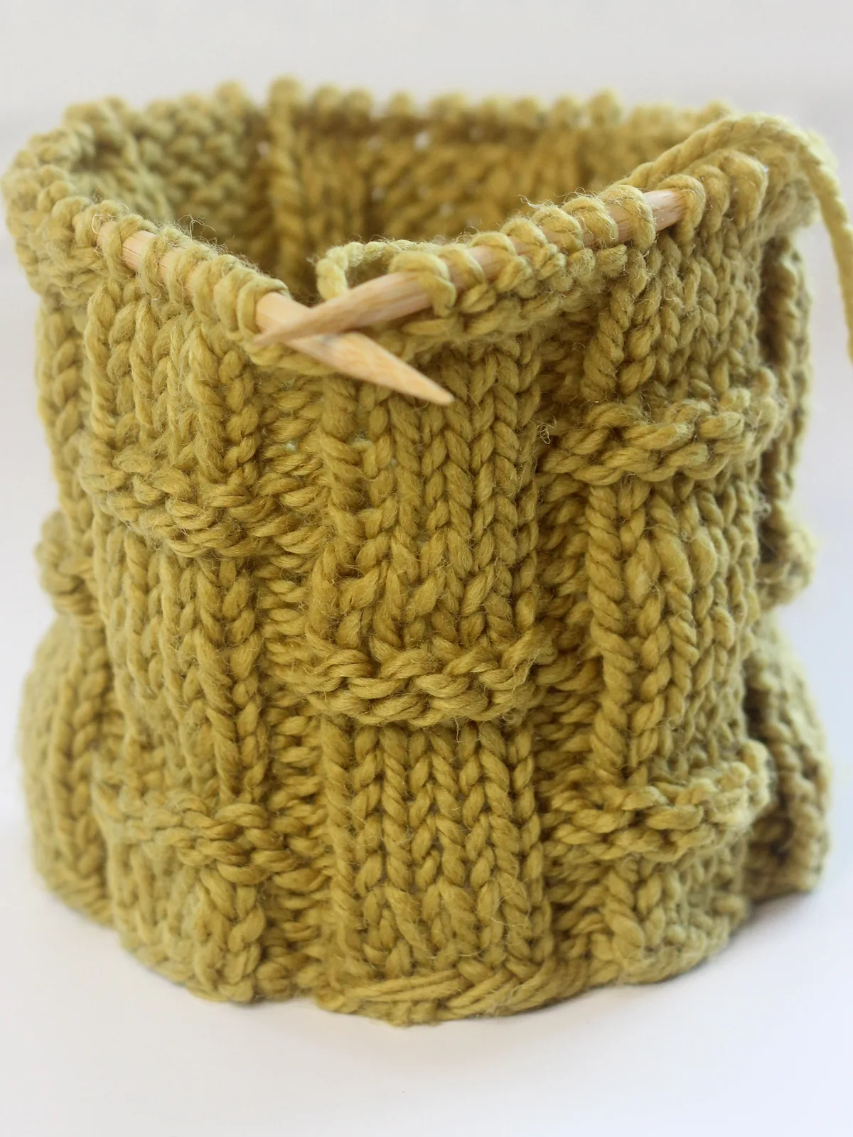 Bamboo Ribbing stitch knitted on circular needles in the round with olive green colored yarn.