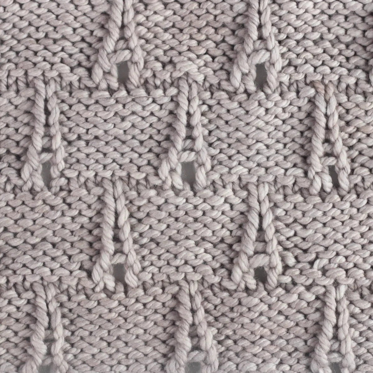 Eiffel Tower knitting pattern texture in gray colored yarn.