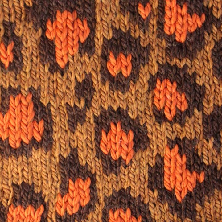 Leopard Print knit stitch stranded colorwork pattern in tan, dark brown, and orange colored yarn.