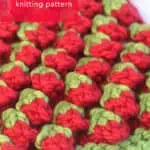 Close-up side view of the strawberry bobble knitting pattern in red and green colored yarn on a knitting needle by Studio Knit.