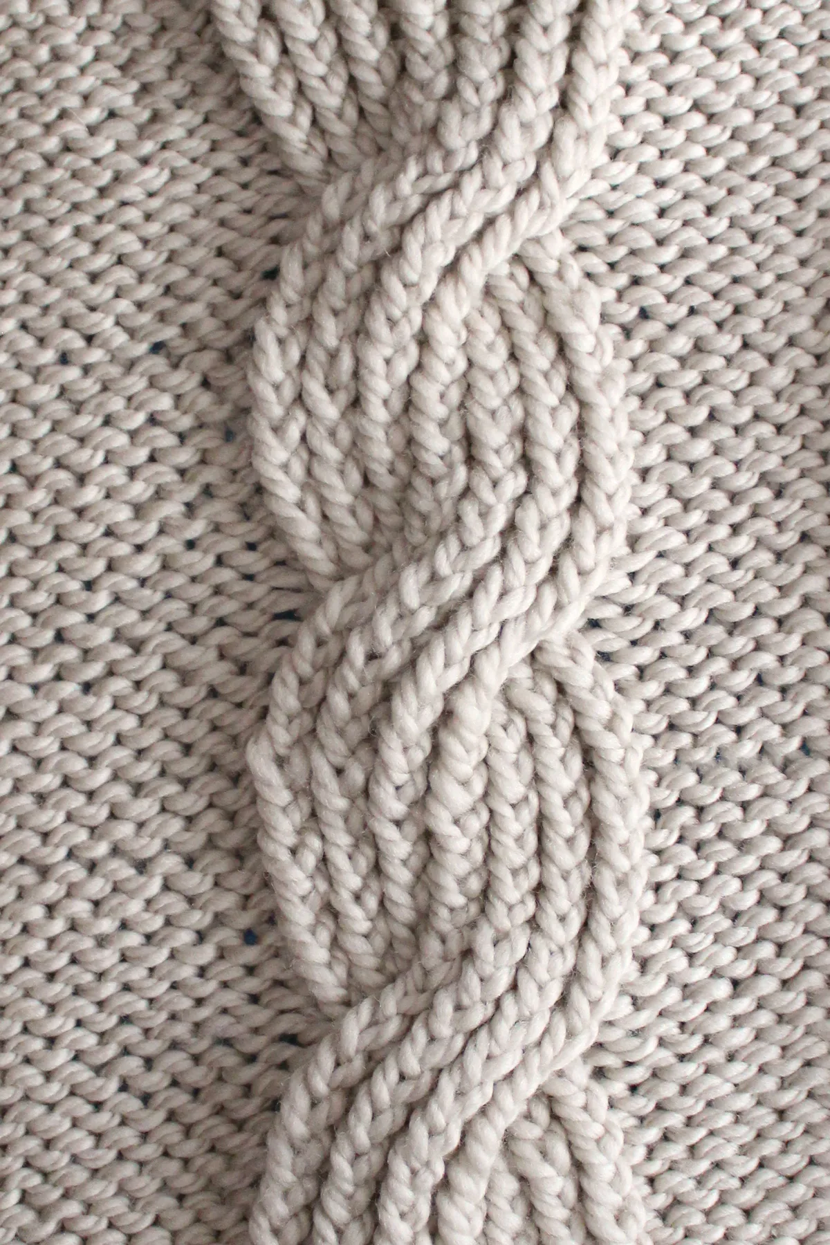 Seven seas cable ribbing knit stitch pattern in beige colored yarn.
