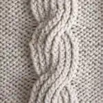 Seven seas cable ribbing knit stitch pattern in beige colored yarn.