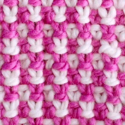 Linen stitch knitting texture with pink and white yarn colors.