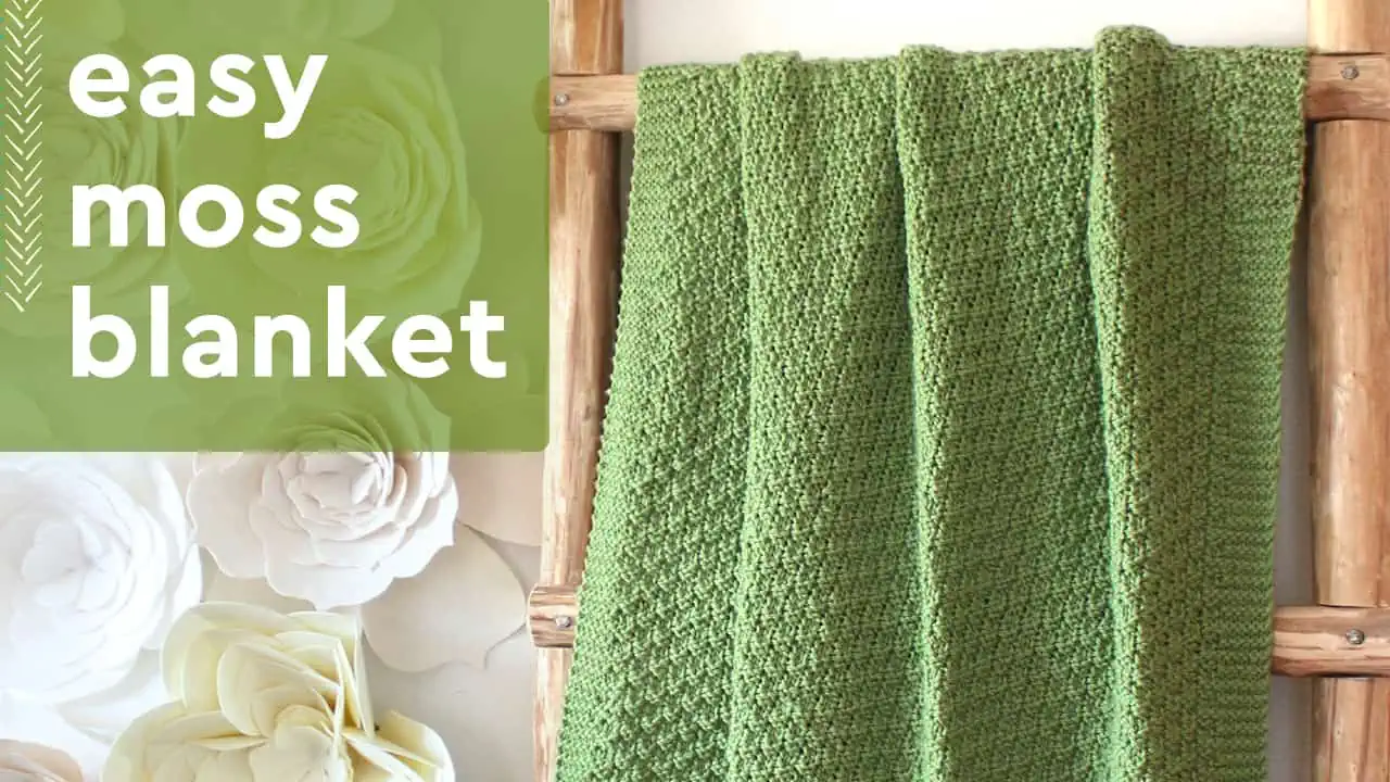 Easy Moss Blanket with green knitted blanket displayed on a wooden ladder.