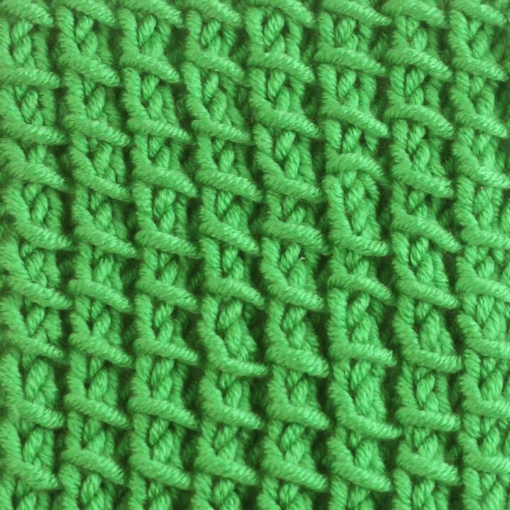 Bamboo Stitch texture knitted with green colored yarn on wooden needle.