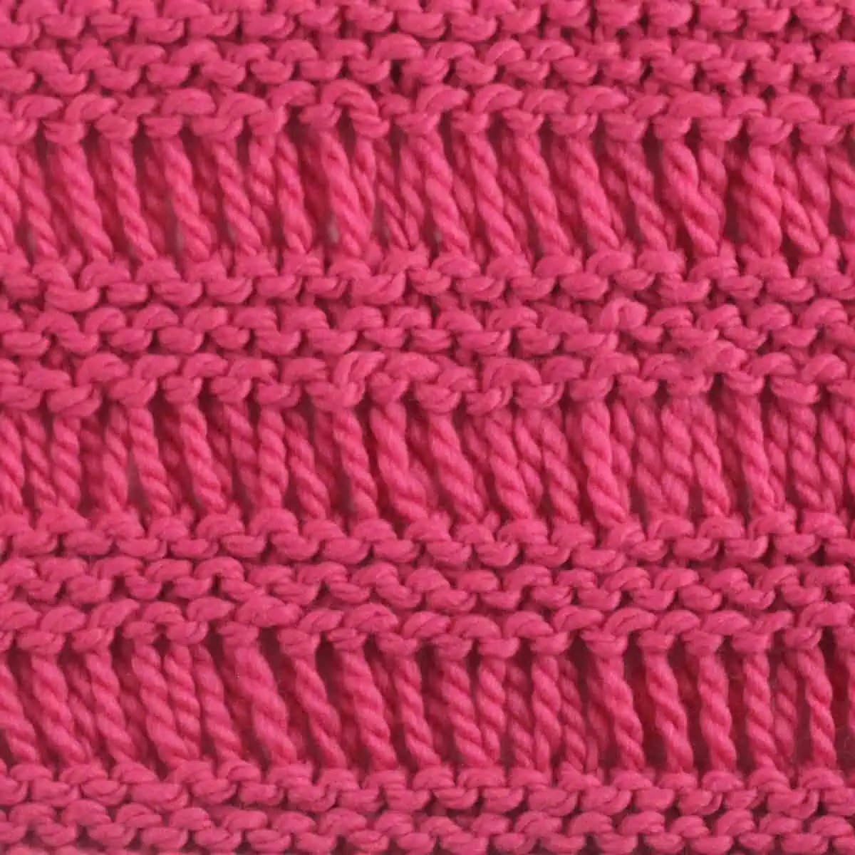 Garter Drop Stitch knitting pattern in bright pink yarn color.